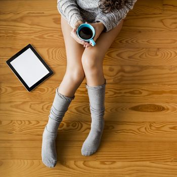 Woman sitting on the floor drinking a coffee 