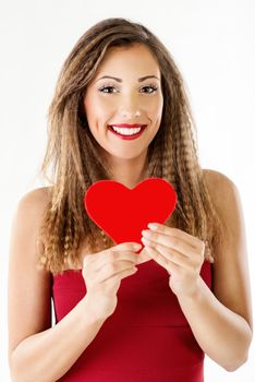 Beautiful smiling girl holding a red heart. Looking at camera.