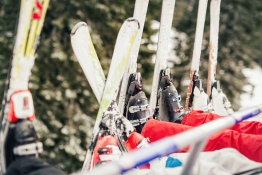 Four unrecognizable skier driving on ski lift. Close-up of a skis.