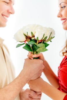 Happy loving couple holding bouquet white roses. Selective focus. Focus on roses.