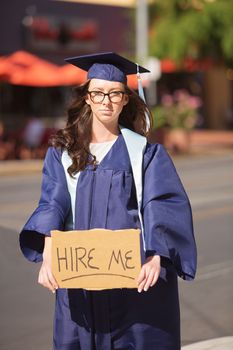 Single graduate with sign begging for a job