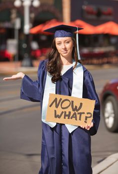 Grinning woman with hand out holding now what? sign