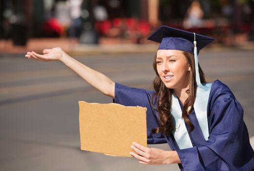 Single college graduate in gown holding blank carboard sign