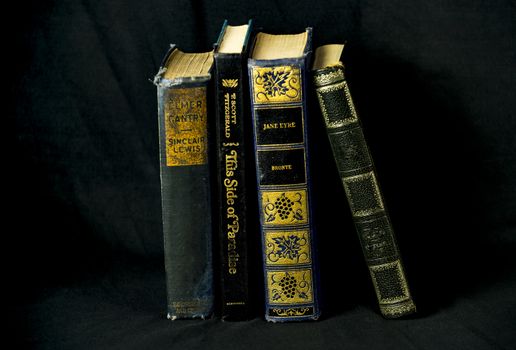 stack of old books on dark black background