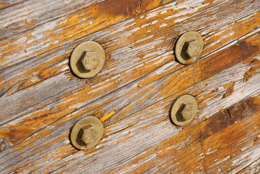Aged varnished wooden texture with bolts.