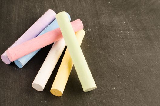 Chalks in a variety of colors arranged on a chalkboard background