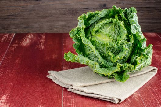 Fresh savoy cabbage closeup on rustic wooden background
