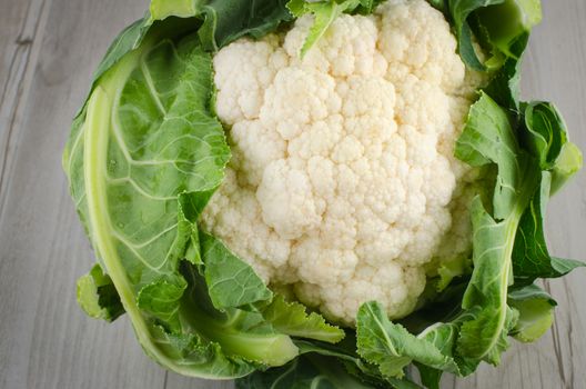 Fresh cauliflower closeup on rustic wooden background