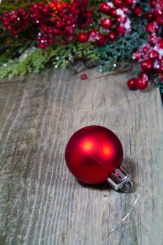 A red Christmas decoration ornament on a wooden background.