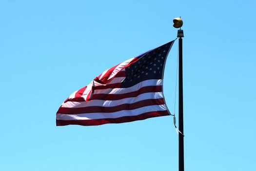 USA flag with a blue sky in the background.