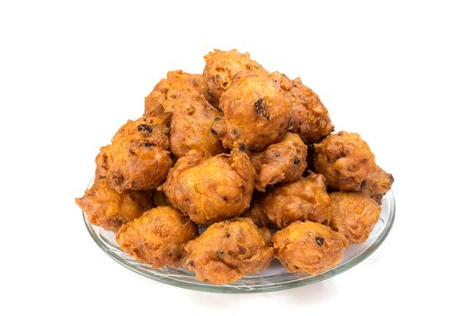 Heap of fried dutch fritters or oliebollen on scale isolated on white background