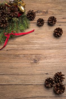 Christmas border design with pine cone, fir branches and ribbon over old oak wood