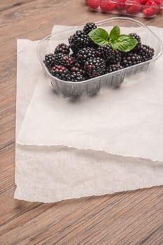 Ripe sweet blackberries and raspberries on wood table background