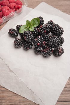 Ripe sweet blackberries and raspberries on wood table background