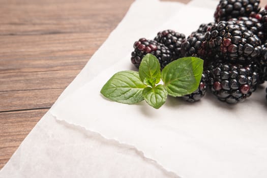 Ripe sweet blackberries on wood table background