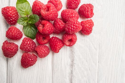 Ripe sweet raspberries on wood table background