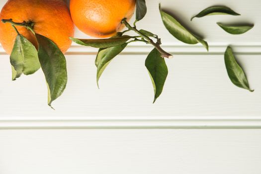 Fresh clementines on wooden board with leaves. Top view with copy space.