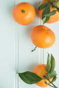 Fresh clementines on wooden board with leaves. Top view with copy space.