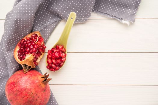 Red ripe peeled pomegranate on rustic wood board background. Top view, copy space