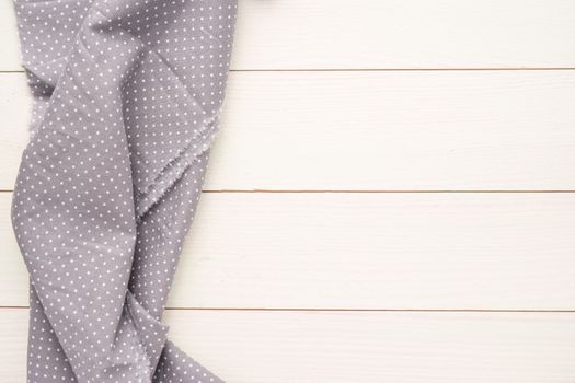 Polka dot fabric over wooden kitchen table. Top of view with copy space