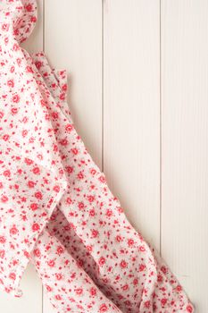 Little flowers fabric over wooden kitchen table. Top of view with copy space