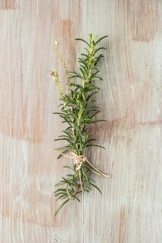 Bunch of fresh of garden rosemary on wooden table, rustic style, fresh organic herbs. Top view with copy space