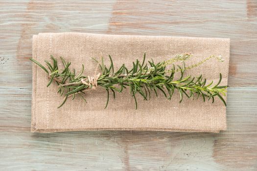 Bunch of fresh of garden rosemary on wooden table, rustic style, fresh organic herbs. Top view with copy space