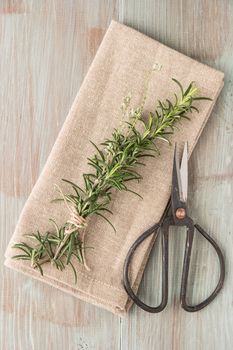 Bunch of fresh of garden rosemary on wooden table, rustic style, fresh organic herbs. Top view with copy space