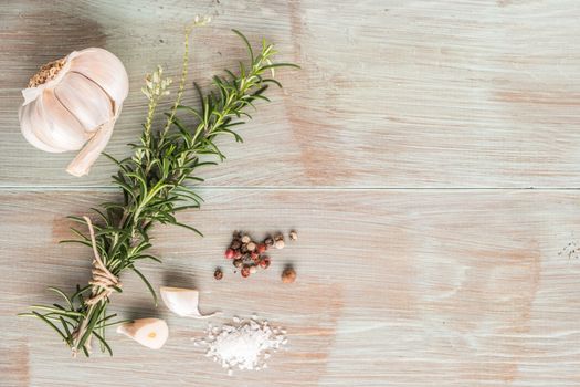 Bunch of fresh of garden rosemary on wooden table, rustic style, fresh organic herbs with salt, chili and garlic. Top view with copy space