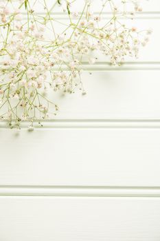 A bouquet of gypsophila flowers lay on the wooden table. Vintage style image. Copy space