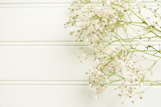 A bouquet of gypsophila flowers lay on the wooden table. Vintage style image. Copy space