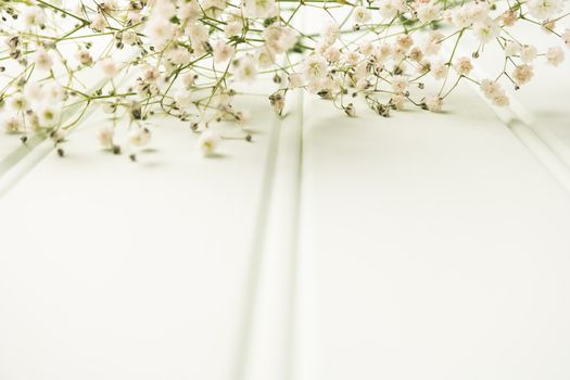 A bouquet of gypsophila flowers lay on the wooden table. Vintage style image. Copy space