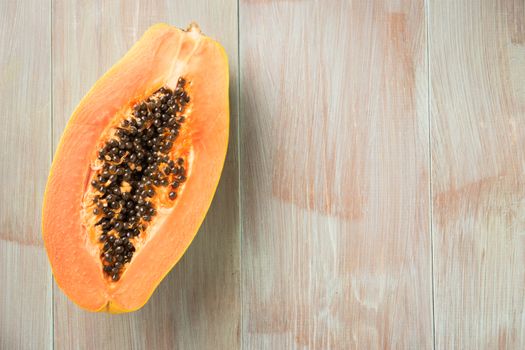 Sliced fresh papaya on wooden background. Top view with copy space