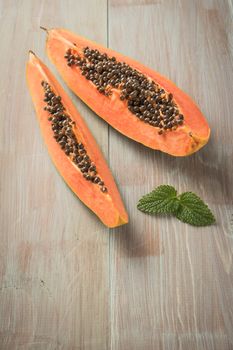 Sliced fresh papaya on wooden background. Top view with copy space