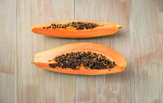 Sliced fresh papaya on wooden background. Top view with copy space