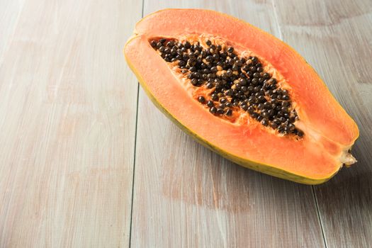 Sliced fresh papaya on wooden background. Top view with copy space