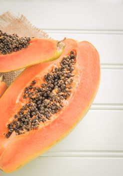 Sliced fresh papaya on wooden background. Top view with copy space