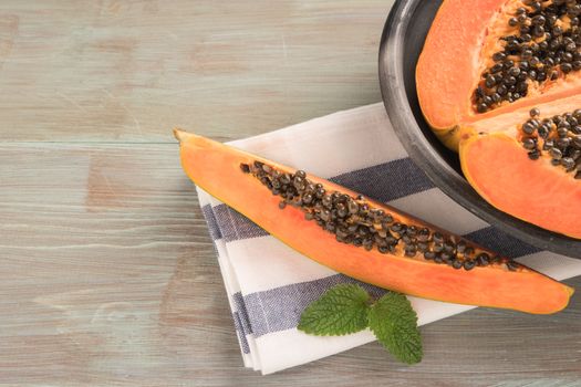 Sliced fresh papaya on wooden background. Top view with copy space