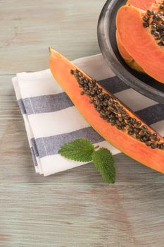 Sliced fresh papaya on wooden background. Top view with copy space