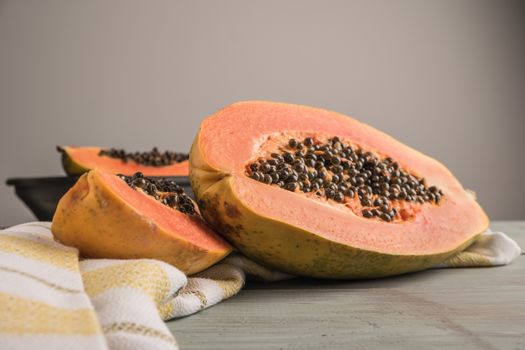 Sliced fresh papaya on wooden background. Top view with copy space