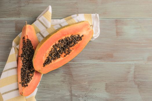 Sliced fresh papaya on wooden background. Top view with copy space