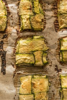 Oven baked courgettes stuffed with cheese, garlic and herbs. Courgette recipe in the oven. Top view with copy space.