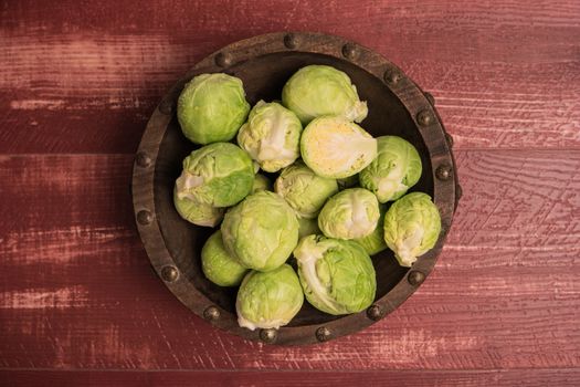 Fresh brussel sprouts over rustic wooden texture. Top view with copy space.