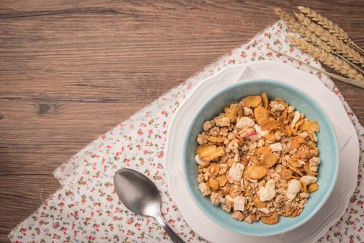 Healthy breakfast with muesli, red apple and cinnamon on rustic wooden table. Top view with copy space.