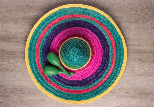 Mexican background. Sombrero and maracas on rustic wooden background. Top view with copy space