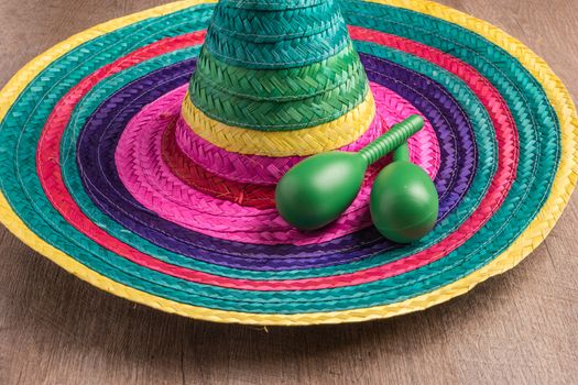 Mexican background. Sombrero and maracas on rustic wooden background. Top view with copy space