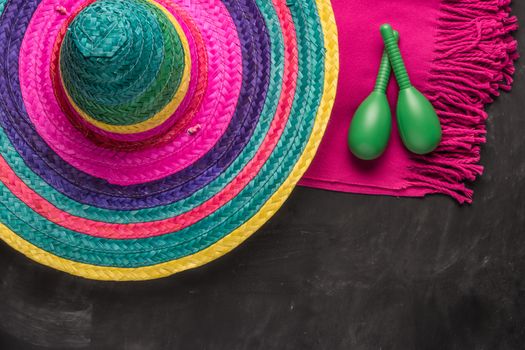 Mexican background. Sombrero, maracas and blankets on rustic slate background. Top view with copy space