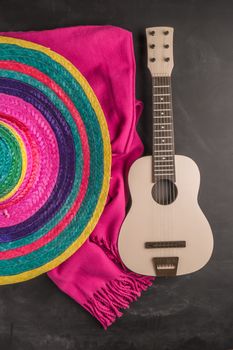Mexican background. Sombrero, guitar and blankets on rustic slate background. Top view with copy space