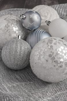 Festive glitter christmas balls decorations on metalic fabric texture. Seasonal winter holidays. Top view with copy space