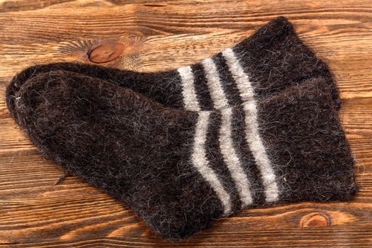 Knitted wool socks on a brown wooden background